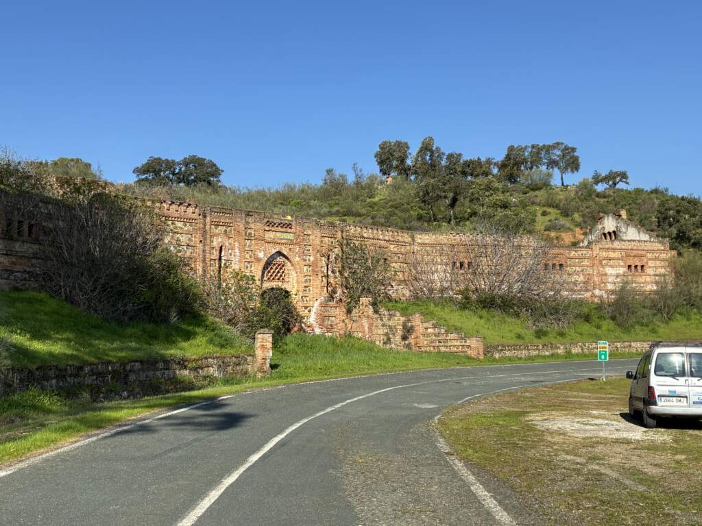 Al salir de una curva, y antes de estar en otra, semejante edificio o la cooperativa colonias del Galeón, ya en ruinas, en El Pedroso en Sierra Morena.